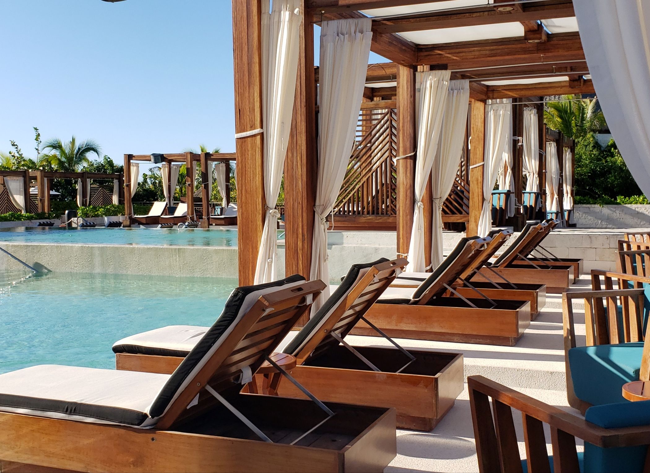 Luxurious poolside equipped with comfortabl lounges and wooden pergolas for amazing relaxation in Costa Rica