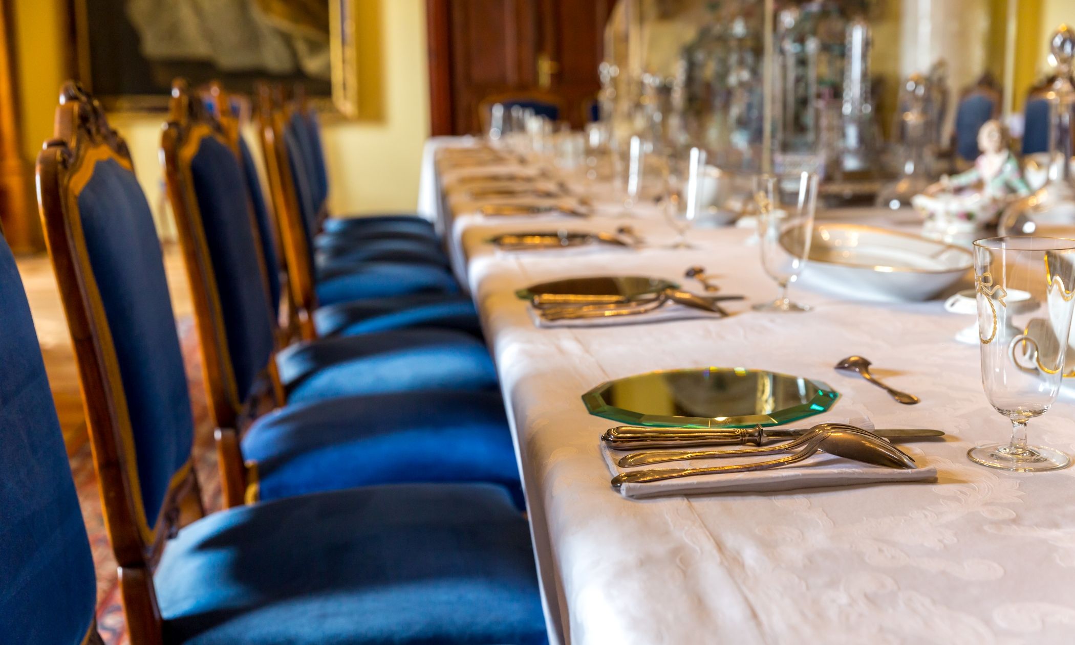 Dining room in a luxury hotel with gorgeous blue and gold chairs, and the table ready for diners at a high end hotel in Miami.