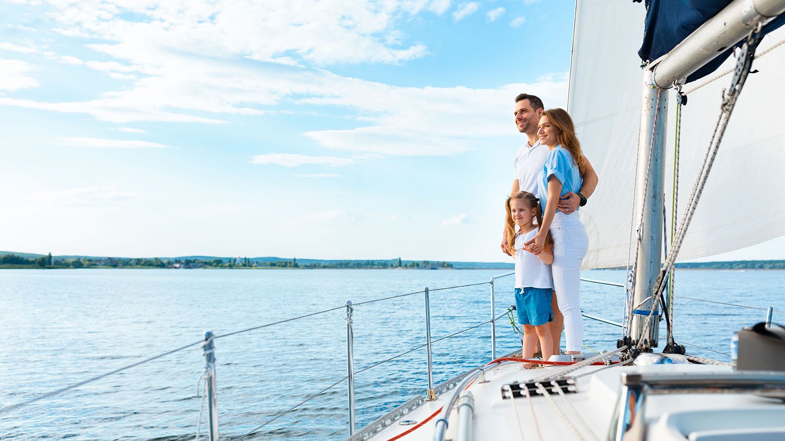Family Standing On Yacht Deck Sailing Across The Sea for Fathers Day.
