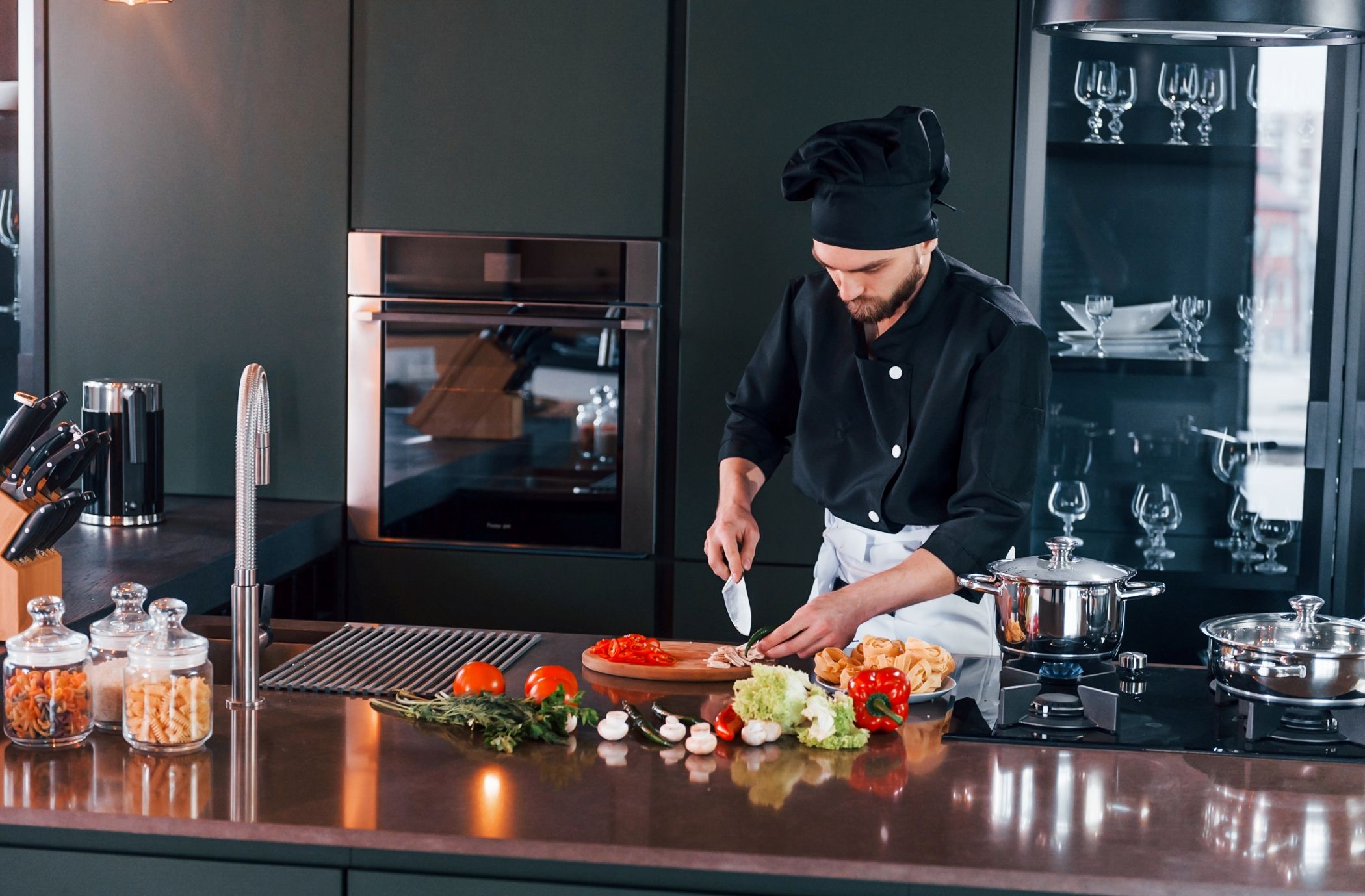 Professional young chef cooks a meal in a private villa for guests on vacation in Miami.